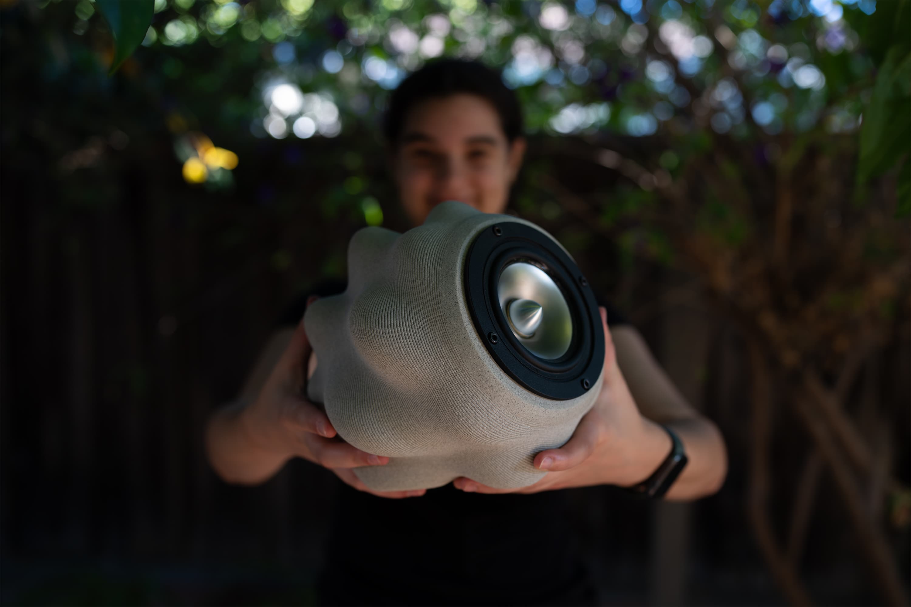 Olivia sostiene al aire libre el altavoz de cerámica terminado e impreso en 3D.